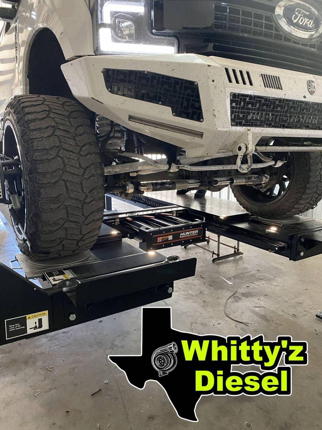 Lifted Ford Super Duty on a Hunter alignment rack at Whitty'z Diesel