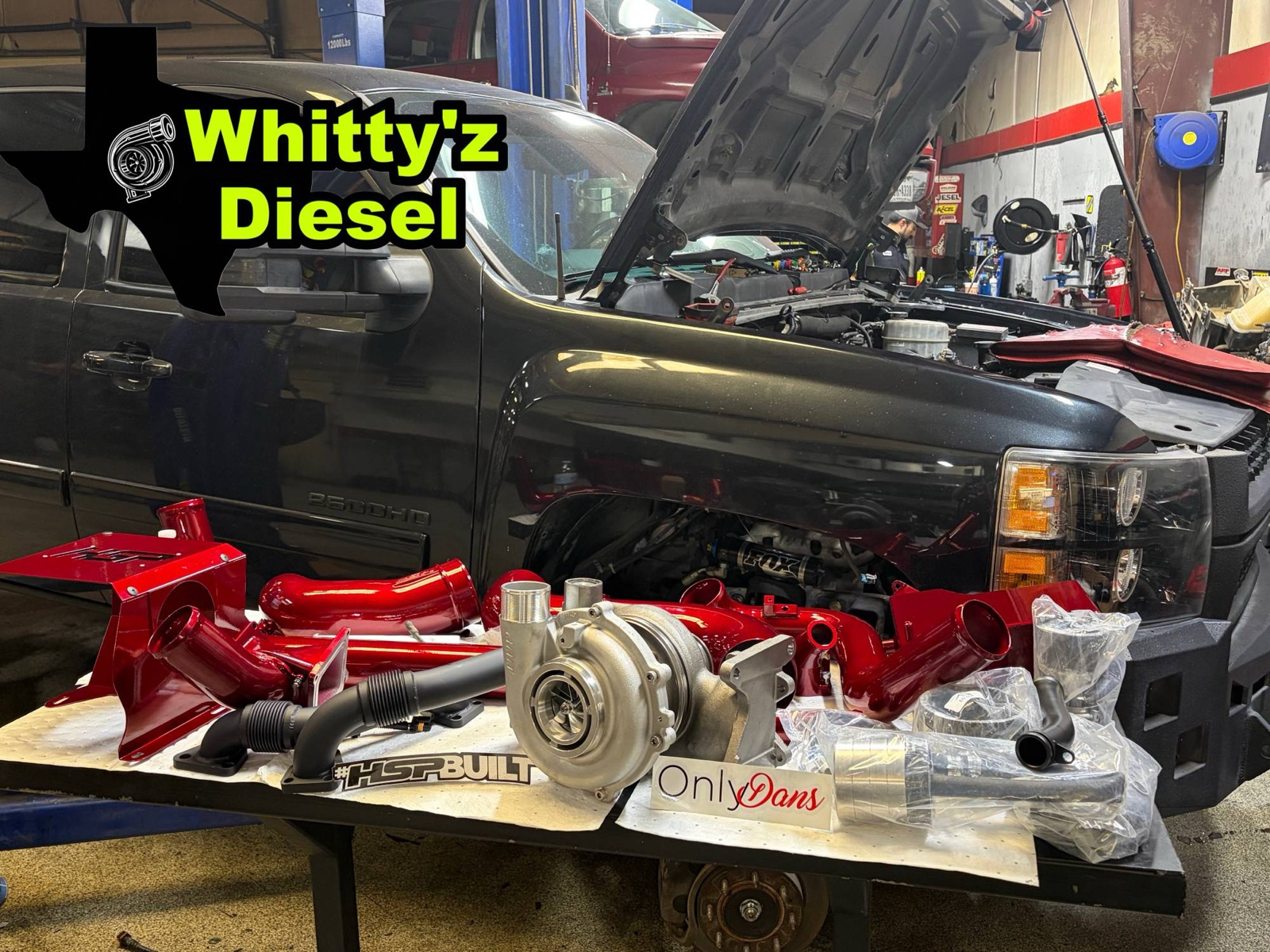 Whitty'z Diesel turbo upgrade kit laid out in front of a Chevy 2500HD